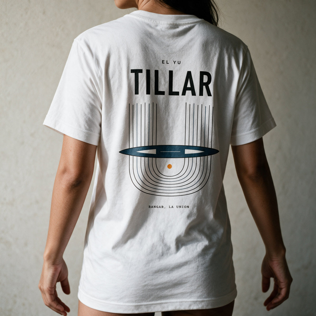 Woman in the white Tillar tee, back view, TILLAR over the Ilocano handloom print