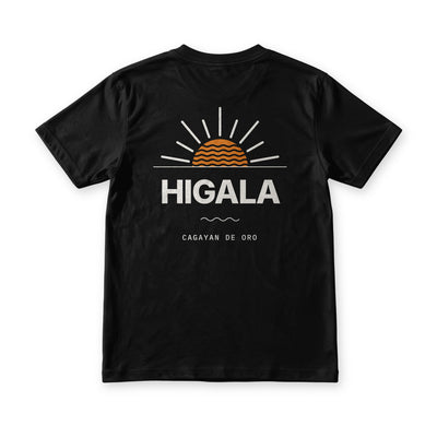 Higala tee in Midnight Black, back view, HIGALA under an orange sunrise with waves inside it and Cagayan de Oro below