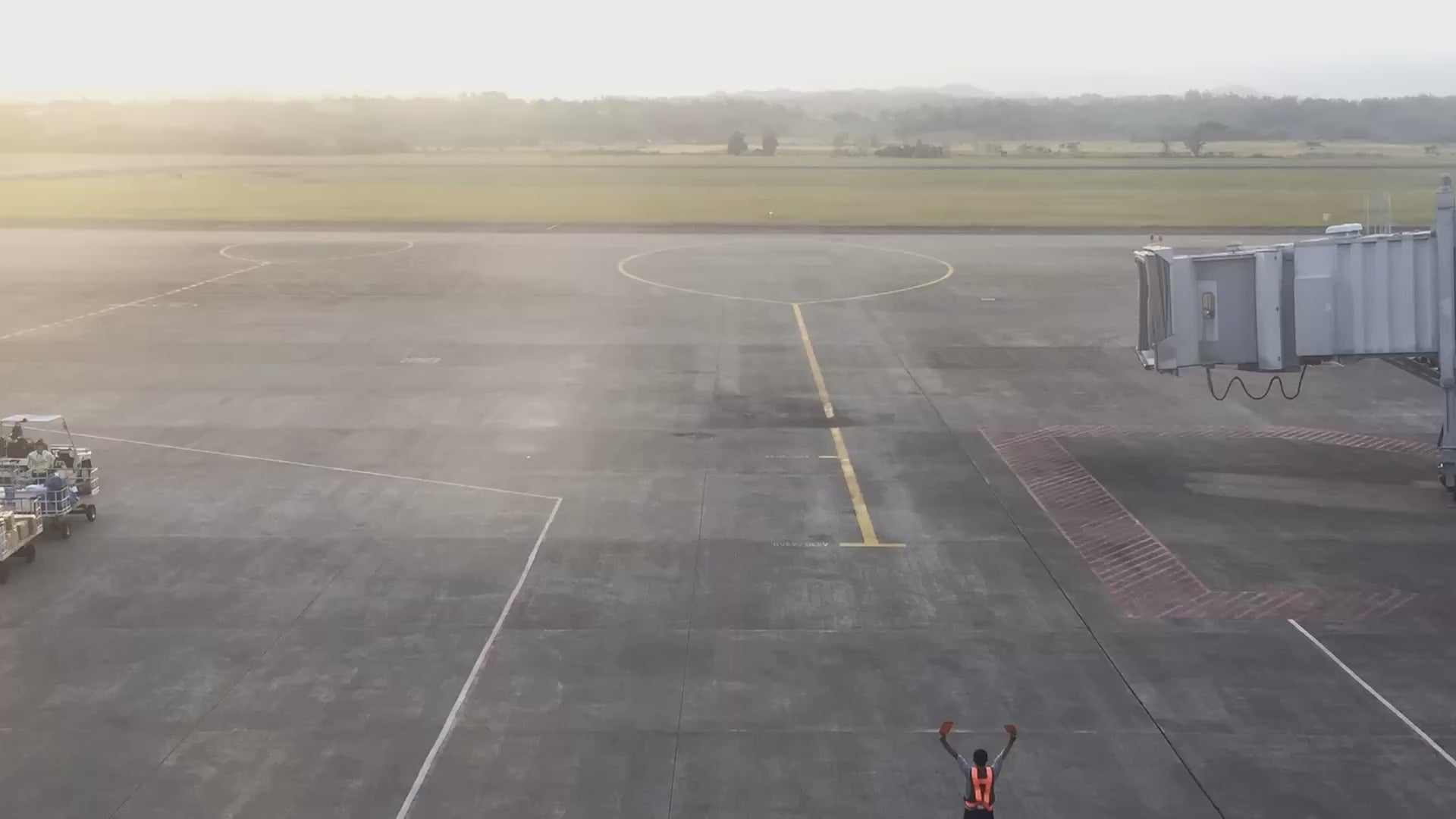 Load video: Aircraft arriving at a gate at Iloilo International Airport at sunset, ground crew marshalling it in