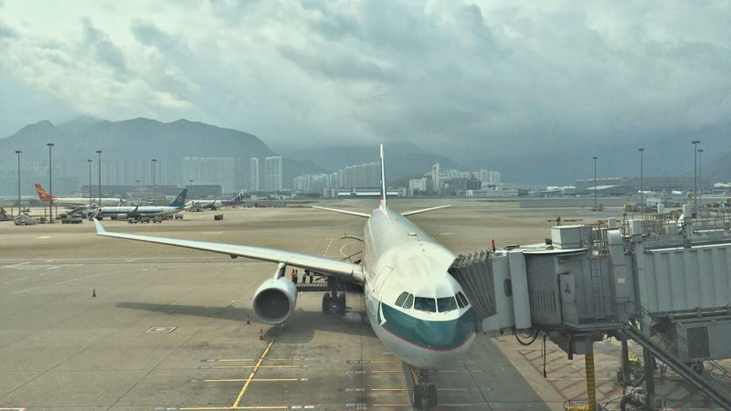 Cathay Pacific aircraft at a Hong Kong International Airport gate, Lantau hills behind