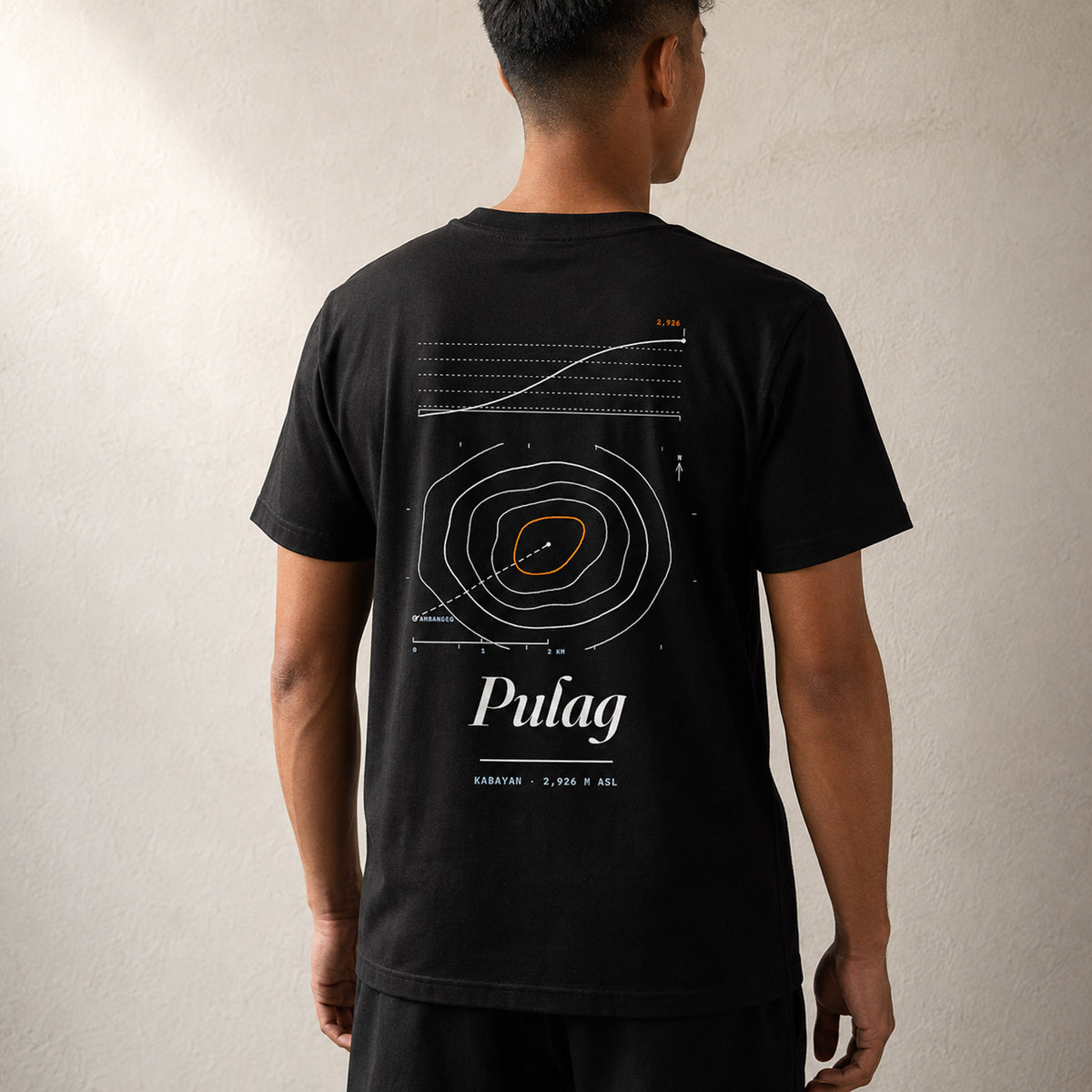 Man seen from behind in the Midnight Black Pulag tee, contour map and 2,926 m elevation profile across his back